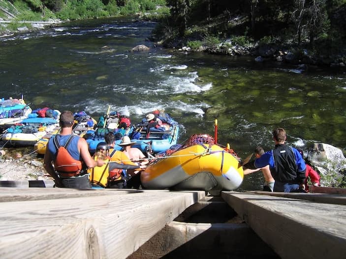Several people waiting in their rafting boats to get into the cocodrile river known as such due to its green-looking water