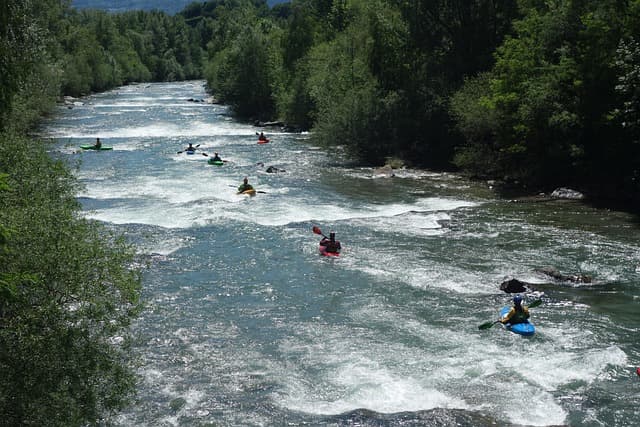 A bunch of one single rafting boats starting their trip down the rapids river surrounded by the forrest