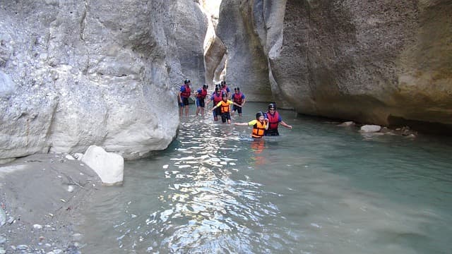 A family rafting group going through a narrow passage in the turkey canyon on foot